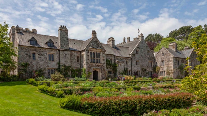 A view of the front of the house and garden at Cotehele on a sunny day, Cornwall